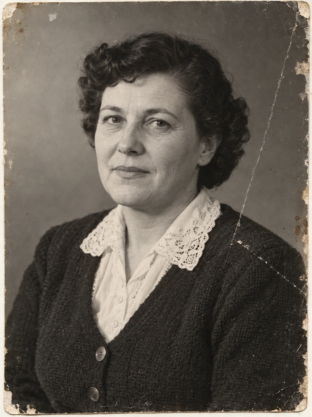 Codex-generated fictional black-and-white portrait of a middle-aged woman with short dark curls, a closed-mouth expression, a light blouse, and a dark cardigan with two round buttons. Edge stains and a diagonal scratch appear on the image’s right side.